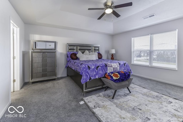 bedroom featuring ceiling fan, a raised ceiling, and carpet floors