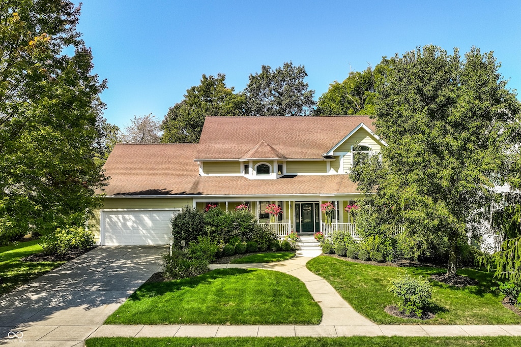 view of front facade with a front yard, a porch, and a garage