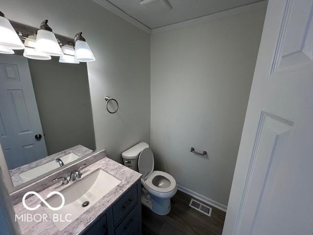 bathroom with toilet, vanity, and hardwood / wood-style flooring