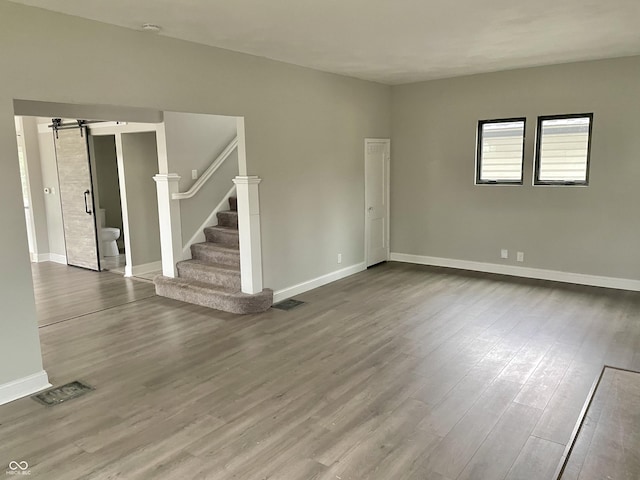 empty room featuring hardwood / wood-style flooring and a barn door