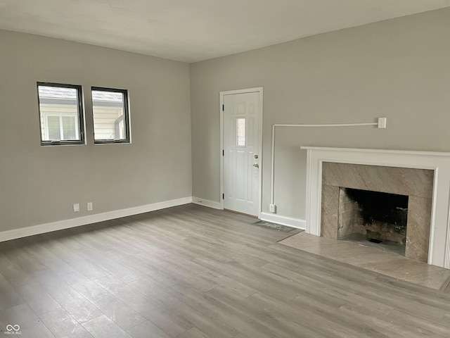 unfurnished living room featuring a fireplace and light hardwood / wood-style flooring