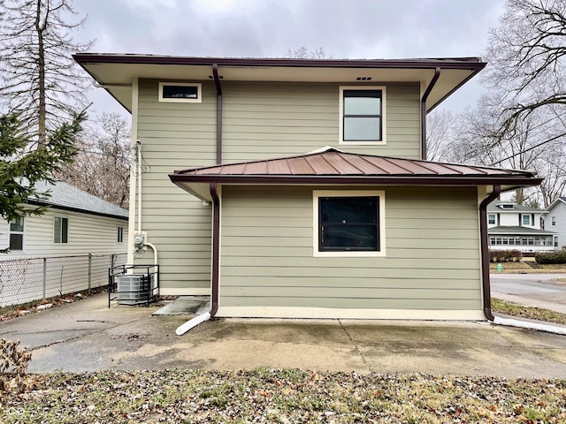 back of property with central AC unit and a patio area