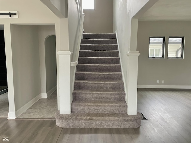 stairs featuring hardwood / wood-style flooring and a wealth of natural light