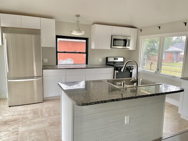 kitchen featuring white cabinets, appliances with stainless steel finishes, and a center island with sink