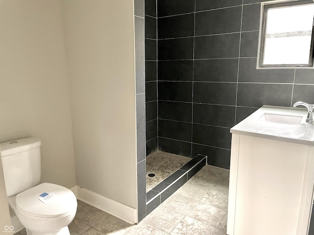 bathroom featuring tiled shower, vanity, and toilet