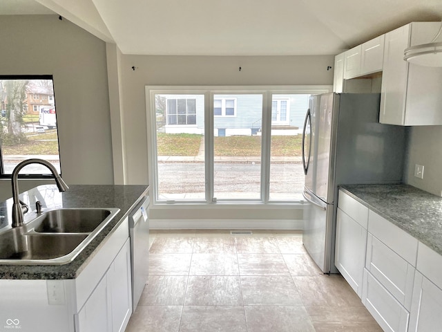 kitchen with sink, a wealth of natural light, white cabinets, and appliances with stainless steel finishes