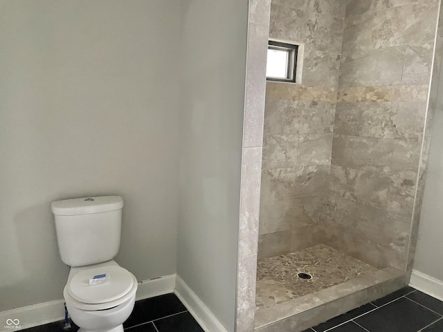 bathroom with toilet, a shower, and tile patterned floors