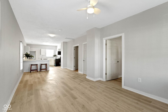 unfurnished living room with ceiling fan and light hardwood / wood-style flooring