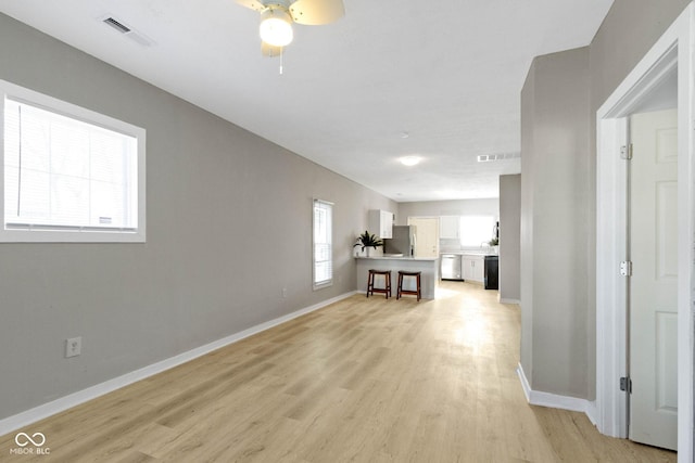 corridor featuring a healthy amount of sunlight and light hardwood / wood-style flooring