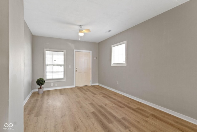 spare room with ceiling fan, a healthy amount of sunlight, and light hardwood / wood-style floors