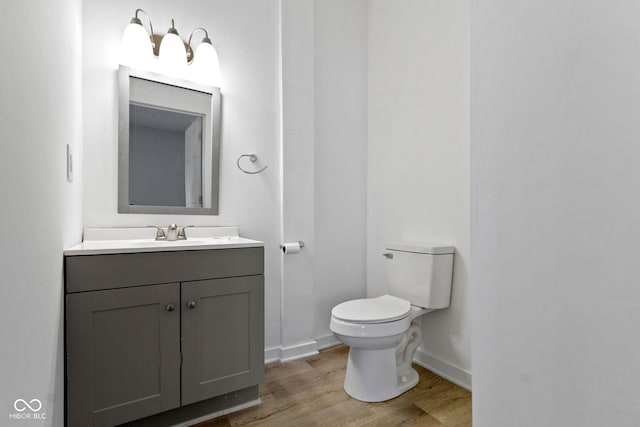 bathroom with hardwood / wood-style floors, vanity, and toilet