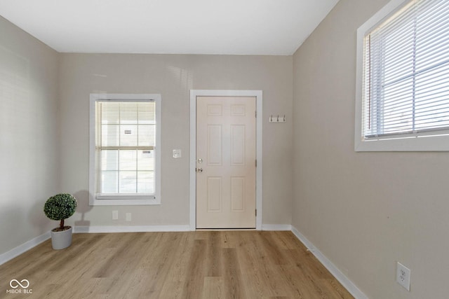 foyer entrance with light hardwood / wood-style flooring and a healthy amount of sunlight