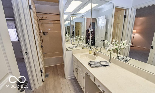 bathroom featuring hardwood / wood-style floors, vanity, and shower / tub combination