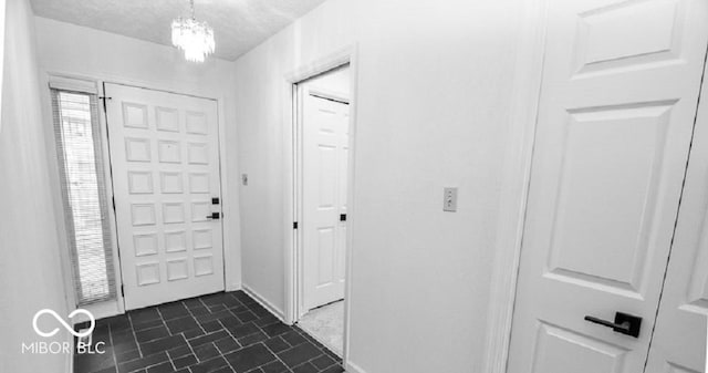 entrance foyer with a textured ceiling and an inviting chandelier