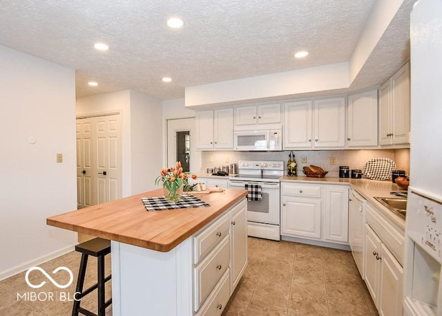 kitchen with white cabinets, white appliances, and a kitchen island