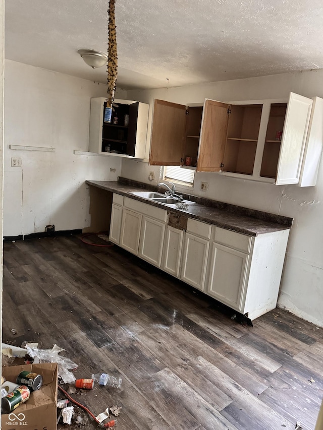 kitchen featuring white cabinets, a textured ceiling, dark hardwood / wood-style flooring, and sink