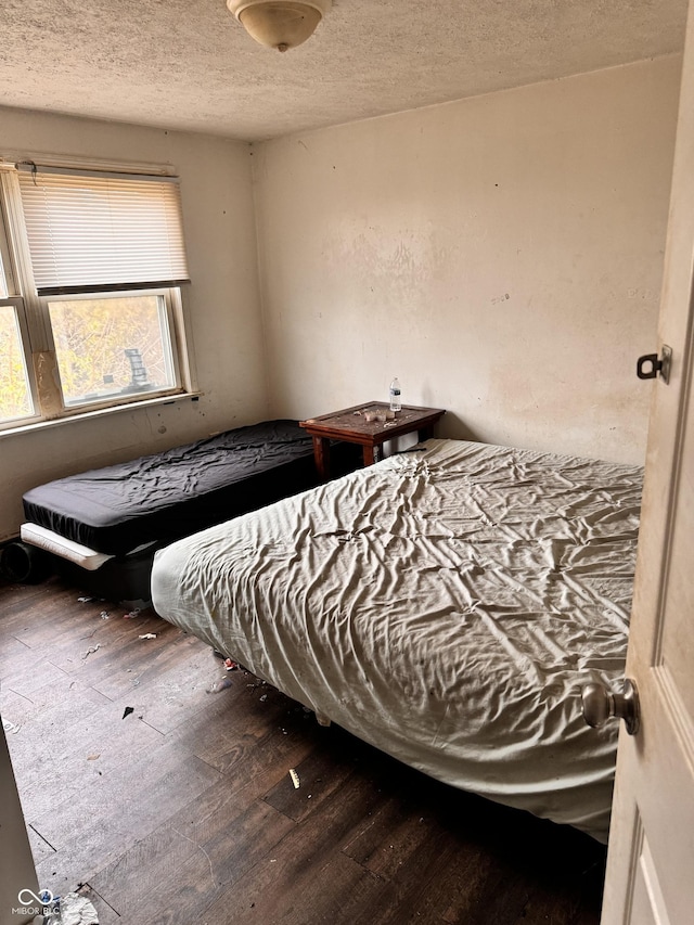 bedroom featuring a textured ceiling and dark wood-type flooring