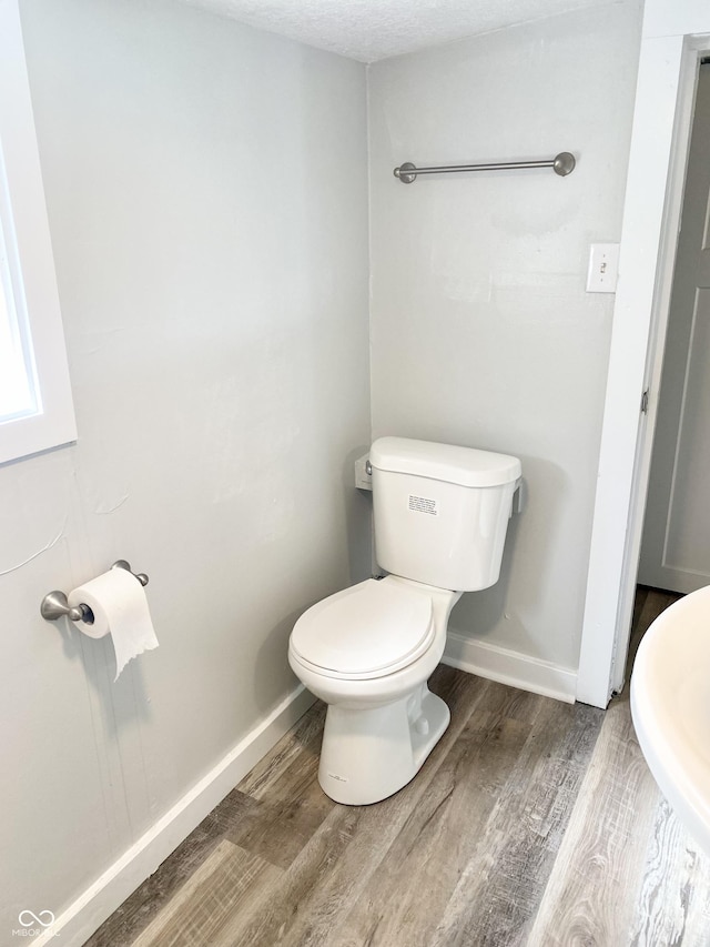 bathroom featuring hardwood / wood-style floors and toilet