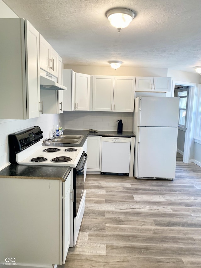 kitchen with tasteful backsplash, sink, white cabinets, and white appliances