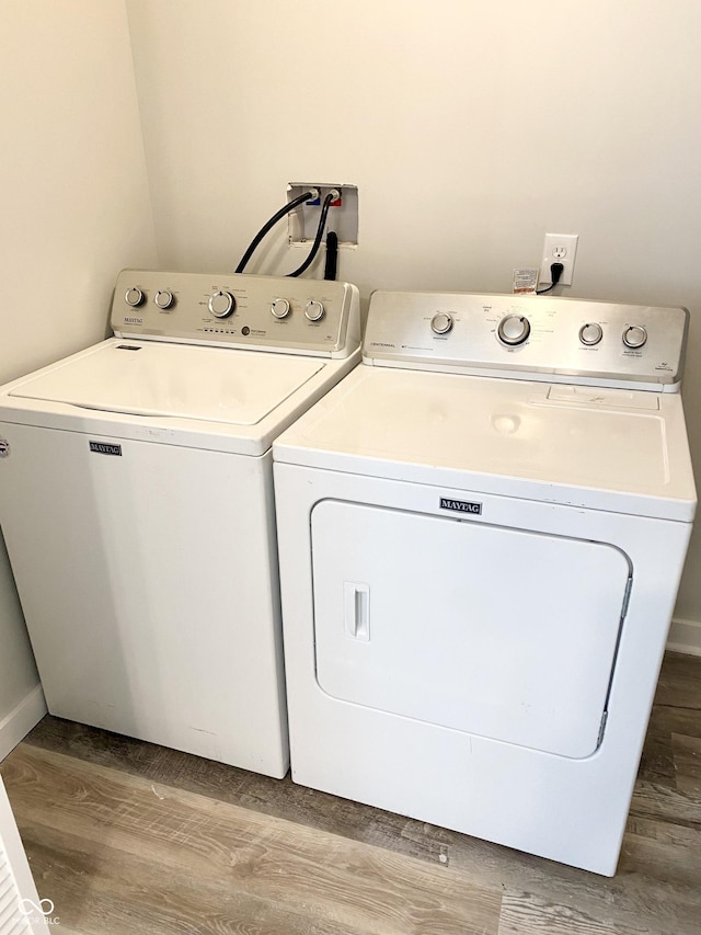 washroom with washer and clothes dryer and light hardwood / wood-style flooring