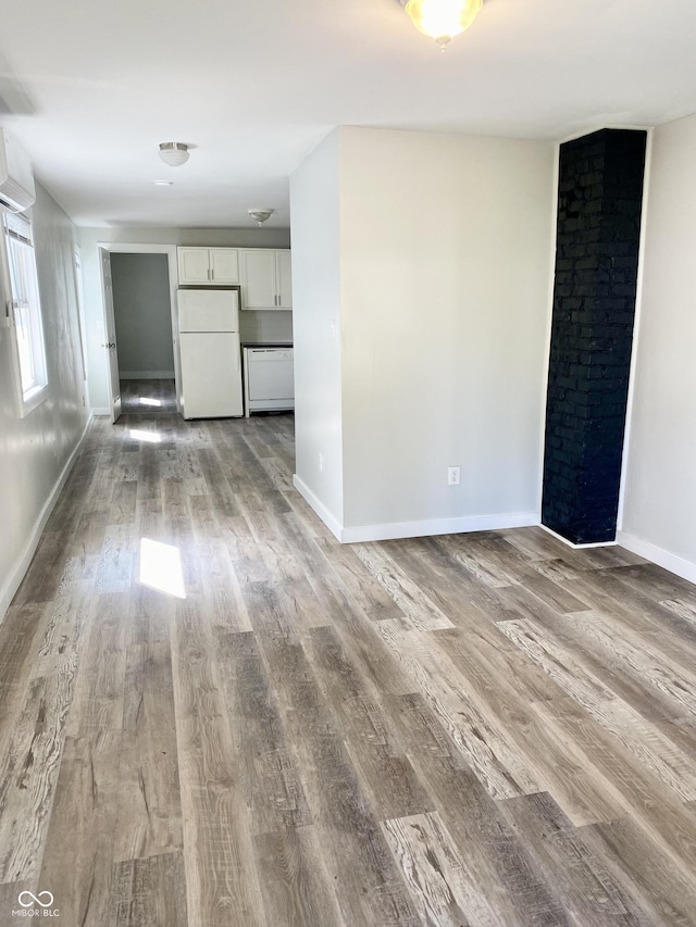 unfurnished room with a wall mounted air conditioner and light wood-type flooring