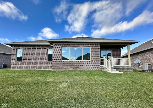 rear view of property with a lawn and central AC unit