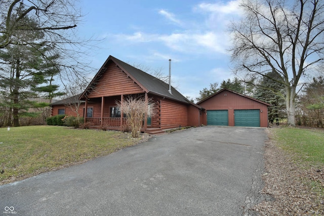 log home featuring an outbuilding, a front lawn, covered porch, and a garage