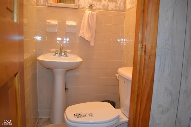 bathroom featuring tile walls and toilet