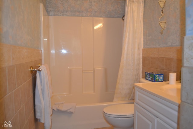 full bathroom featuring vanity, shower / bathtub combination with curtain, toilet, and tile walls