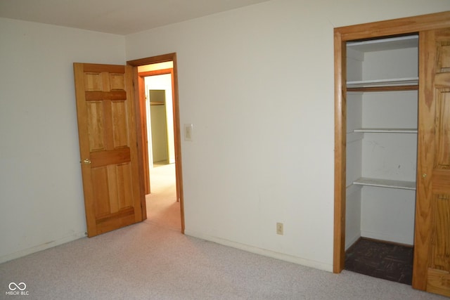 unfurnished bedroom featuring light colored carpet and a closet