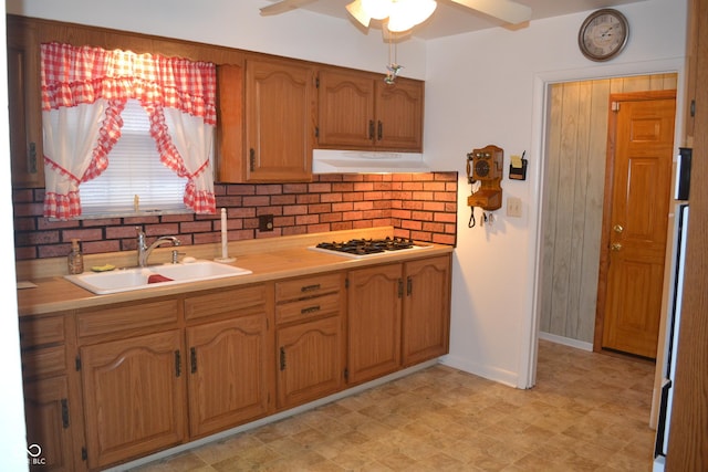 kitchen featuring decorative backsplash, white gas stovetop, ceiling fan, and sink