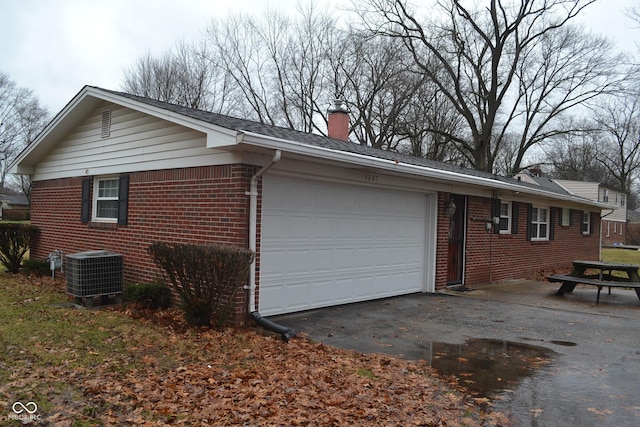 view of side of home featuring a garage and central AC unit