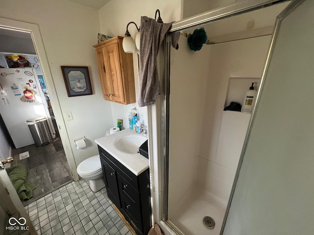 bathroom with tile patterned flooring, vanity, toilet, and a shower with door