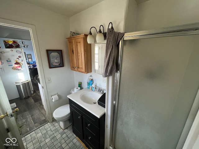 bathroom with vanity, toilet, and a shower with door