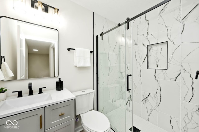 bathroom with vanity, a shower with shower door, and toilet