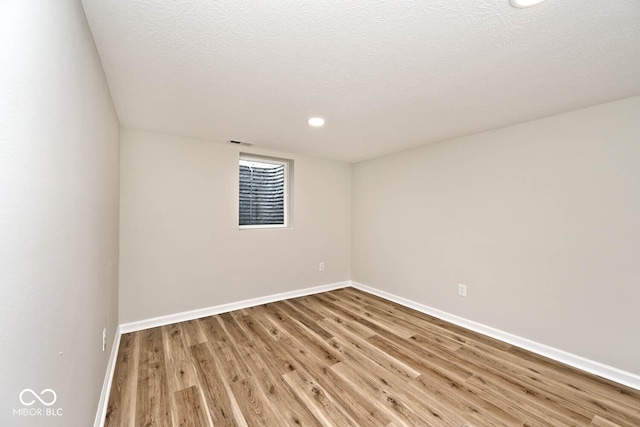 empty room featuring wood-type flooring and a textured ceiling