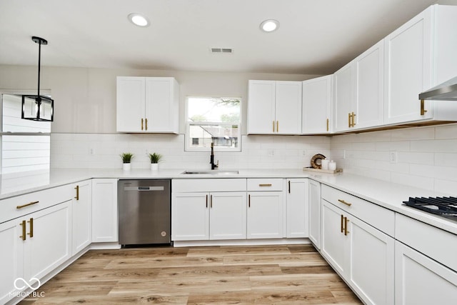 kitchen with stainless steel dishwasher, pendant lighting, white cabinets, and sink