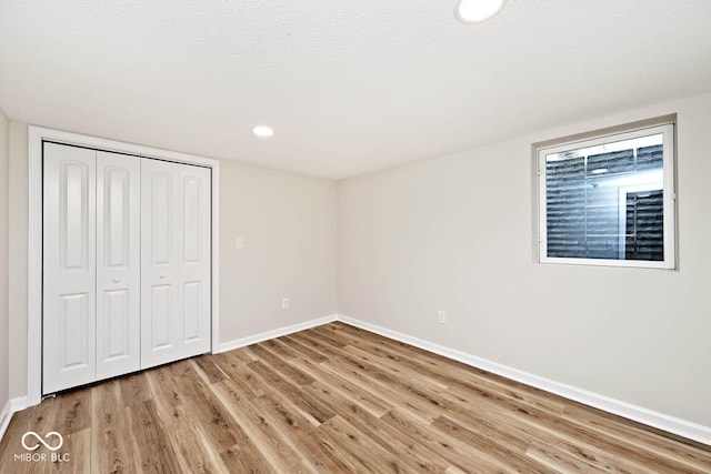 unfurnished bedroom featuring light wood-type flooring and a closet