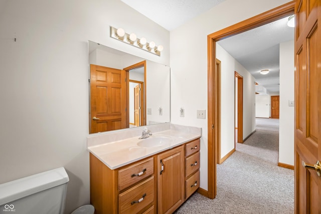 bathroom with vanity, a textured ceiling, and toilet