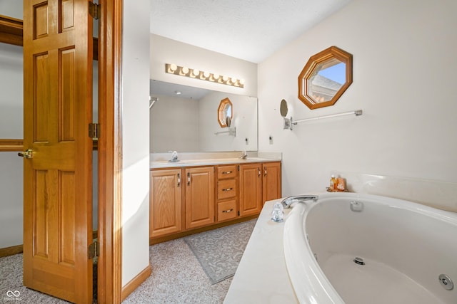 bathroom featuring a textured ceiling, vanity, and a tub