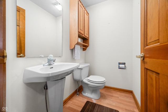 bathroom with hardwood / wood-style flooring and toilet