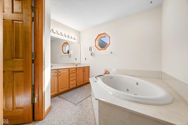 bathroom featuring vanity, a textured ceiling, and a tub