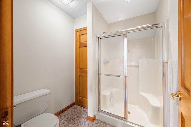 bathroom with toilet and a shower with door