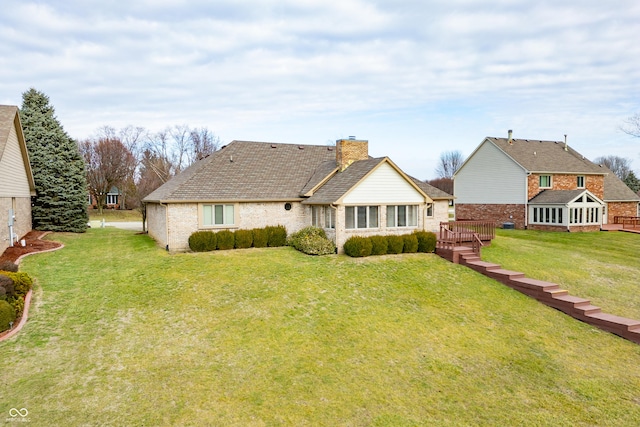 rear view of house featuring a lawn