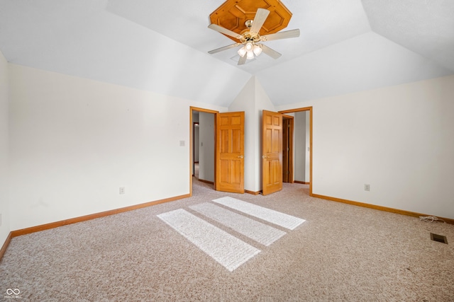 unfurnished bedroom featuring ceiling fan, lofted ceiling, and light carpet