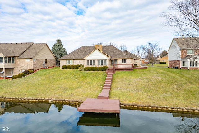 back of property featuring a lawn and a deck with water view