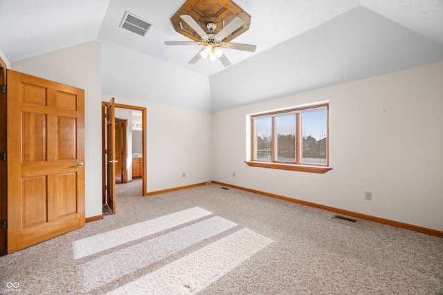 unfurnished bedroom with ceiling fan, light colored carpet, and lofted ceiling