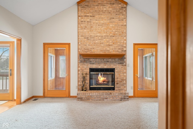 unfurnished living room featuring carpet floors, high vaulted ceiling, and a brick fireplace