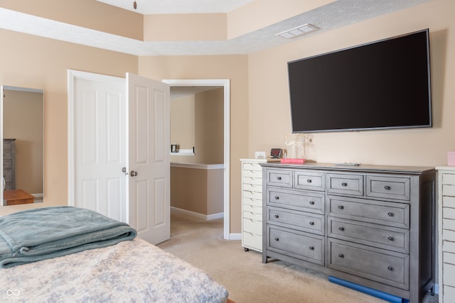 bedroom with light carpet and a textured ceiling