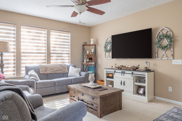 carpeted living room with ceiling fan, a textured ceiling, and a wealth of natural light